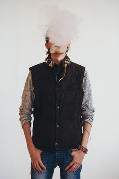 Portrait of young man smoking electronic cigarette