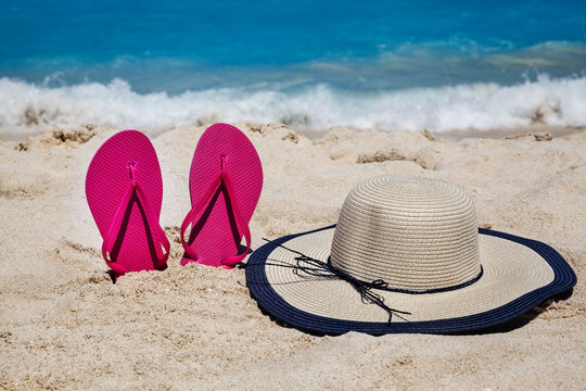 Tropical beach in the summer with flip flops and hat