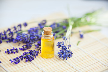 Essence of lavender flowers on table in beautiful glass bottle
