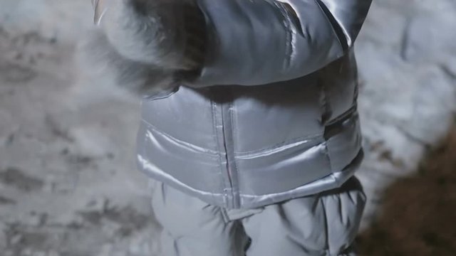 Little girl claps hands in mittens from snow in slowmotion