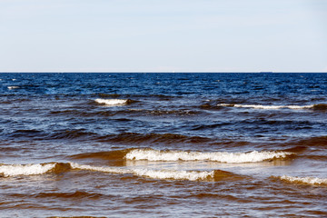 sunny summer scene of Baltic sea with beautiful seaside with waves.