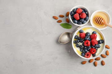 Natural yogurt with fresh berries and honey, healthy breakfast concept, top view, copy space