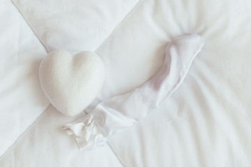 Heart and dildo sex toy on the white blanket