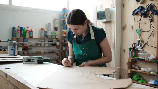 Woman in workshop cutting wood