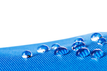 Waterproof fabric with waterdrops close up, on white background