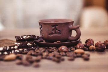 roasted coffee beans with chocolate and nuts on a wooden surface.