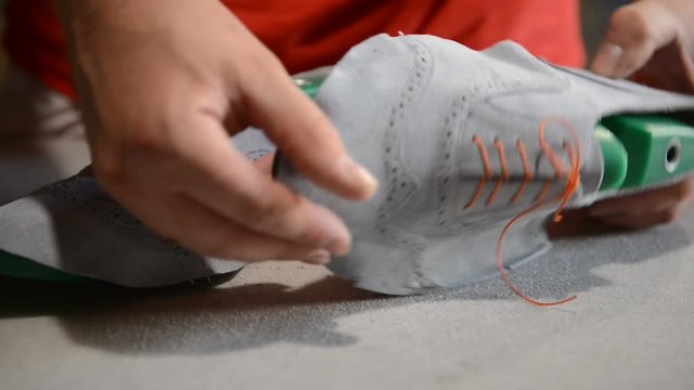 Responsible shoemaker making gray shoes