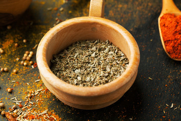 Oregano dry seasoning in a bowl on a dark