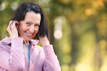Portrait of elderly woman prepare to jog with headphones in the park