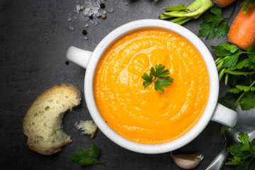 Carrot cream-soup on black table.