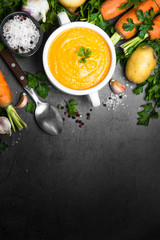 Obraz na płótnie Canvas Carrot cream-soup on black table.