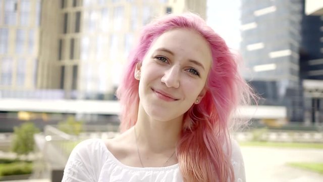 close-up. portrait of teenage girl with pink hair. Sunny day. walk in the center of the city