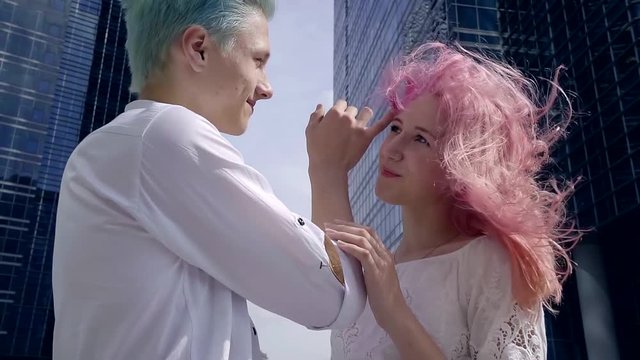 Happy young couple with colorful hair look at each other