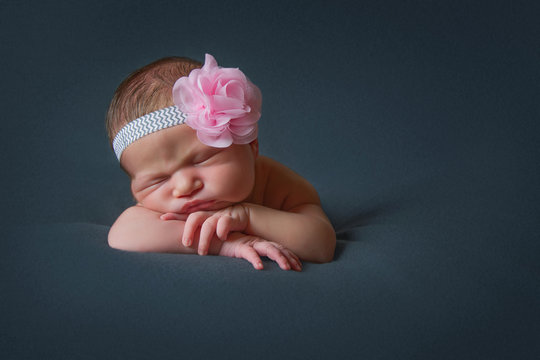 Newborn girl with hairband sleeps