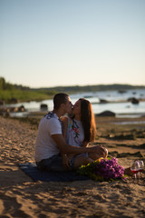 A young couple in love, on the shore of the Bay at sunset