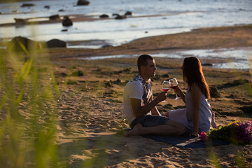 A young couple in love, on the shore of the Bay at sunset