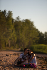 A young couple in love, on the shore of the Bay at sunset