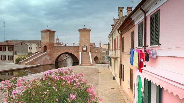 timelapse of typical Italian hamlet, where drying colorful clothes are hanging from window overlooking ancient bridge, color graded clip