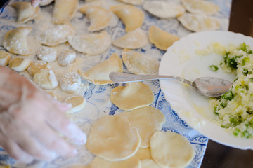 Making dumplings, ravioli busy kitchen table background, closeup top side view