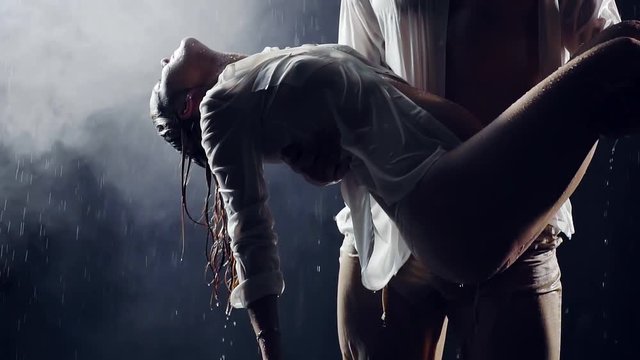 slow motion. a man with big muscles holding the body of his pregnant woman. he prayed her back to life looking up to the sky. night under a big rain