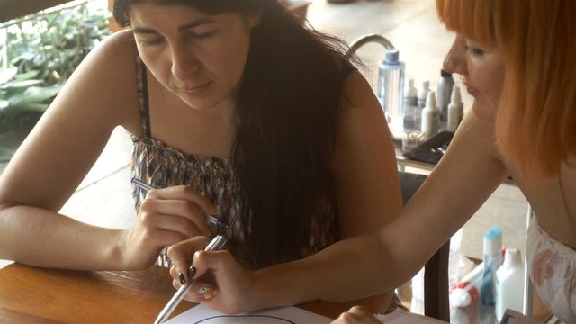 teacher sit at the table and studied painting and eyebrow correction