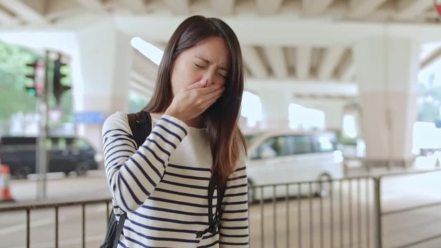 Woman suffer from nose allergy, coughing ans sneezing at city of Hong Kong