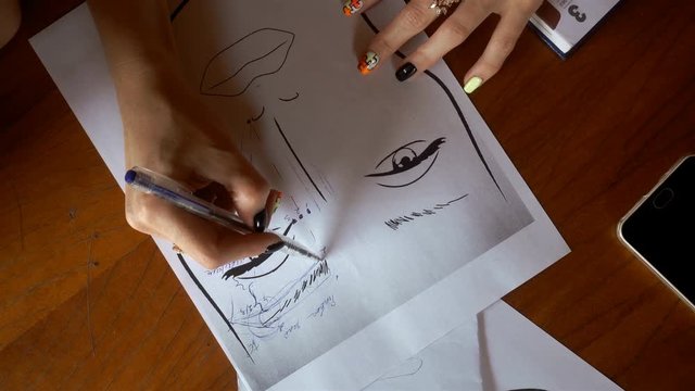 makeup artist draws on paper eyebrows