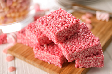 Delicious rice crispy treats on wooden board, closeup