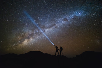 Landscape with Milky Way. Night sky with stars and silhouette of a couple on the mountain. - obrazy, fototapety, plakaty