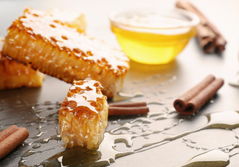 Honeycombs, cinnamon and spilled honey on table