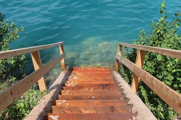 wooden staircase leading down to the blue clean water