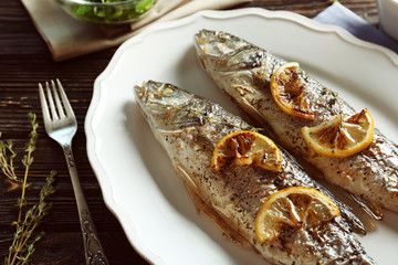 Delicious baked sea bass fish on white plate