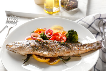 White plate with baked fish and garnish on table