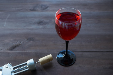wineglass of red wine on dark brown desk