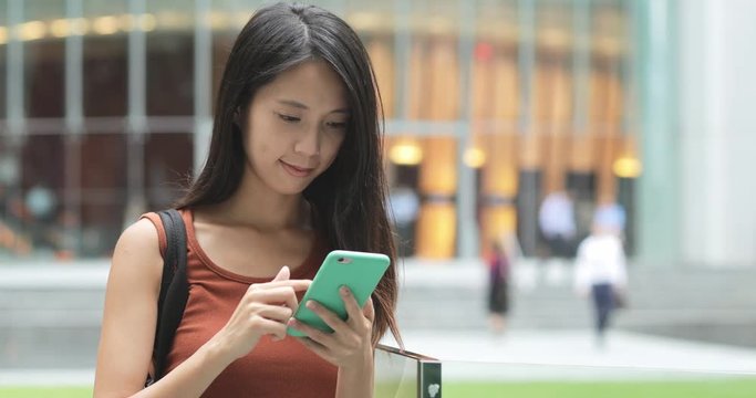 Woman use of smrt phone in the business district