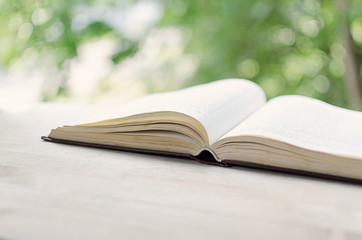 Open book in front of an open window.
