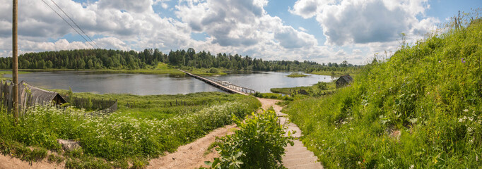 North Russian village. Summer day, river, old cottages on coast.