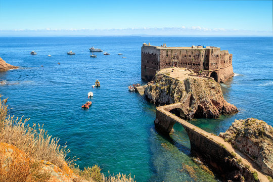 Fort São João Baptista of Berlengas, with anchored boats, seen from Berlenga island, in Portugal, with Peniche coast at sight.