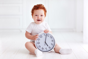 happy little toddler baby holding circle clock