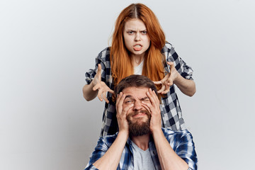 Beautiful young woman and man with a beard on a light background, repair, construction tools