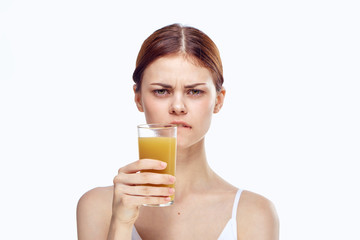 Beautiful young woman on a light background holds a glass of fresh juice, diet, proper nutrition