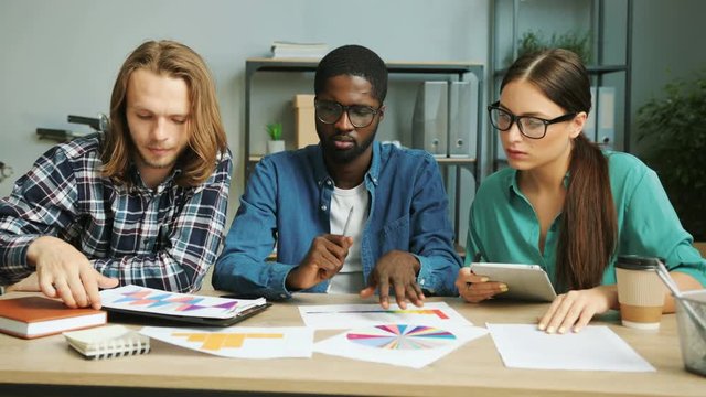 Business partner working together in modern office, analizing business documents, reports and diagrams from the last year finance report.