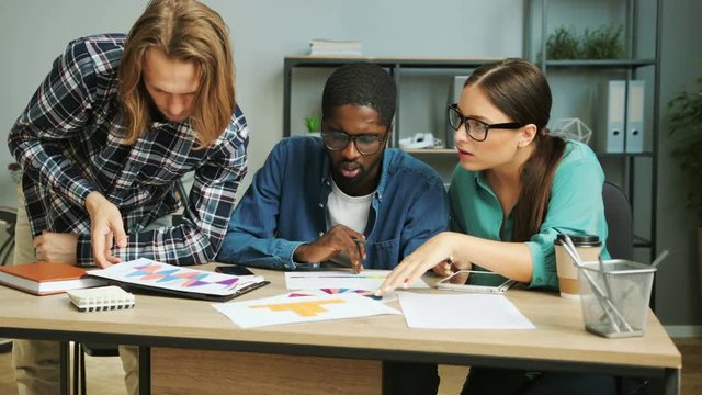 Business partner working together in modern office, analizing business documents, reports and diagrams for creating new global project.