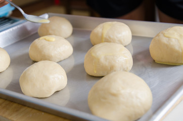 Bread dough in baking tray prepare for bake and decorate with creamy