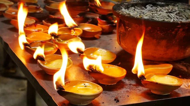 Devotee lighting up candle in the Hindu Temple in Batu Caves Kuala Lumpur Malaysia.