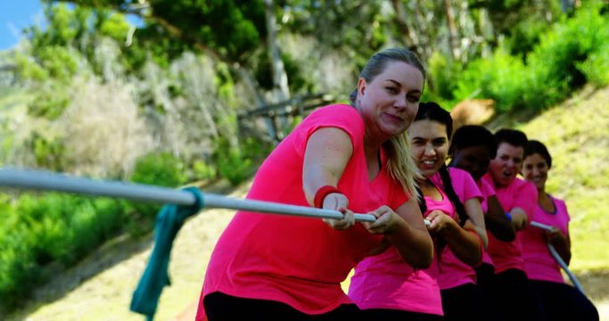 Group of women playing tug of war during obstacle course