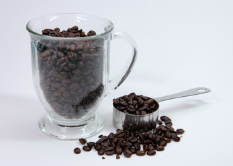 Coffee beans in glass with measuring cup