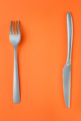 Fork and knife on orange background