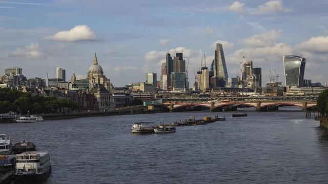 London city Time-Lapse from the Waterloo Bridge with the view of the skyscrapers, the St Paul's Cathedral and the busy Thames with many boats.