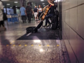 Subway musician making money by playing cello 